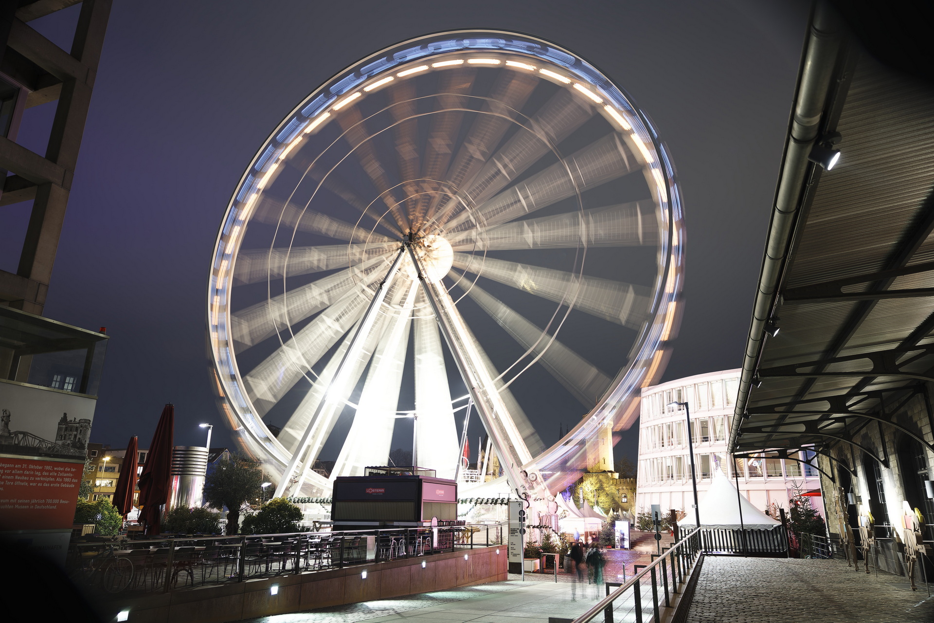 Das Bild zeigt ein sich schnell drehendes Riesenrad vor dem Schokoladenmuseum in Köln